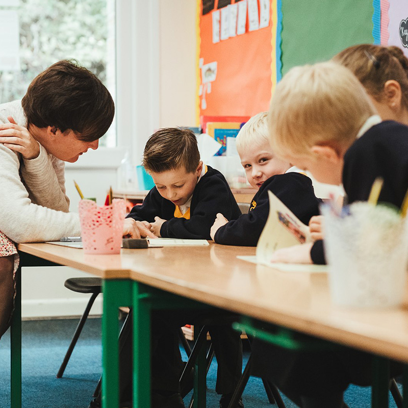 A teacher helping year 1 students at Staplehurst School with their work.