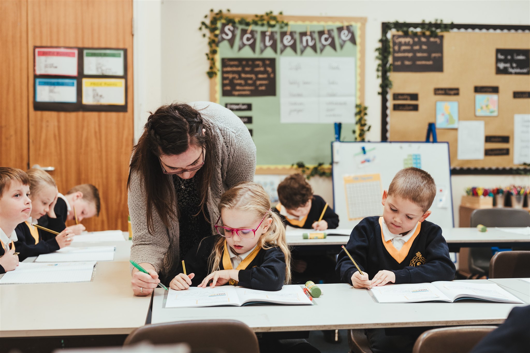 A teacher helping year 2 students with their work at Staplehurst School.