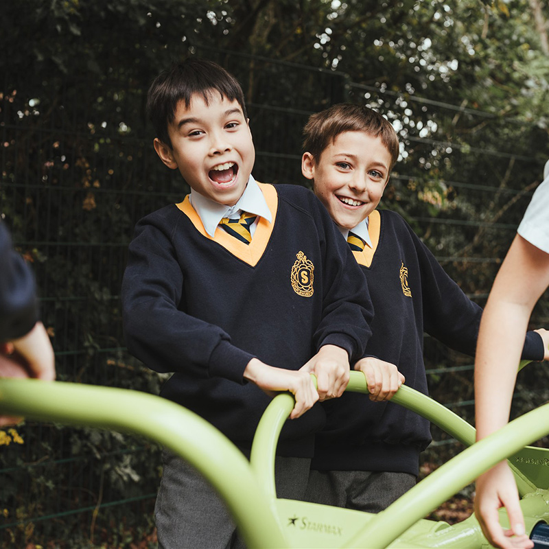 Two year 6 boys at Staplehurst School smiling in the playground.